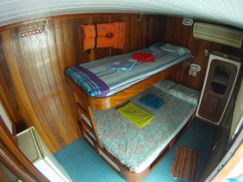 Camarote do barco hotel Yemanjár com beliche em madeira e ar-condicionado